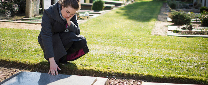 Young adult mourning at grave site