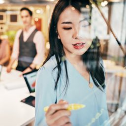 Business woman writting on white board